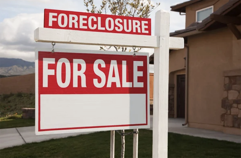 A foreclosure and for sale sign on the lawn of a house - 1 (800) 880-7954
